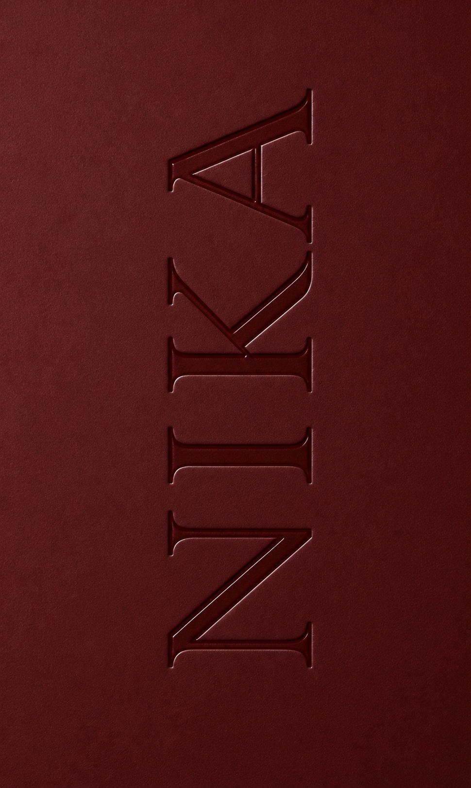 NIKA embossed in deep burgundy cardstock