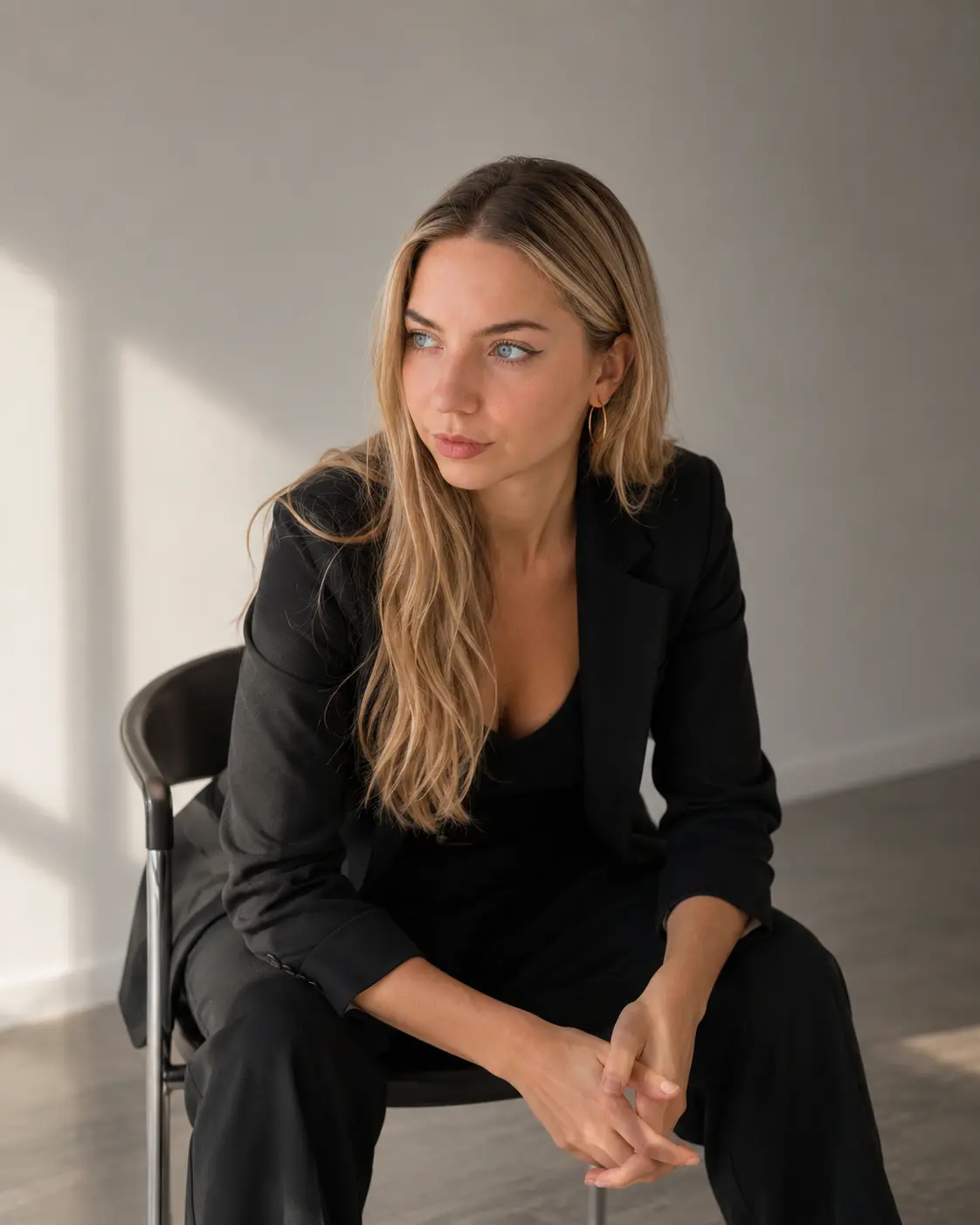 Veronika seated on a chair, hands clasped