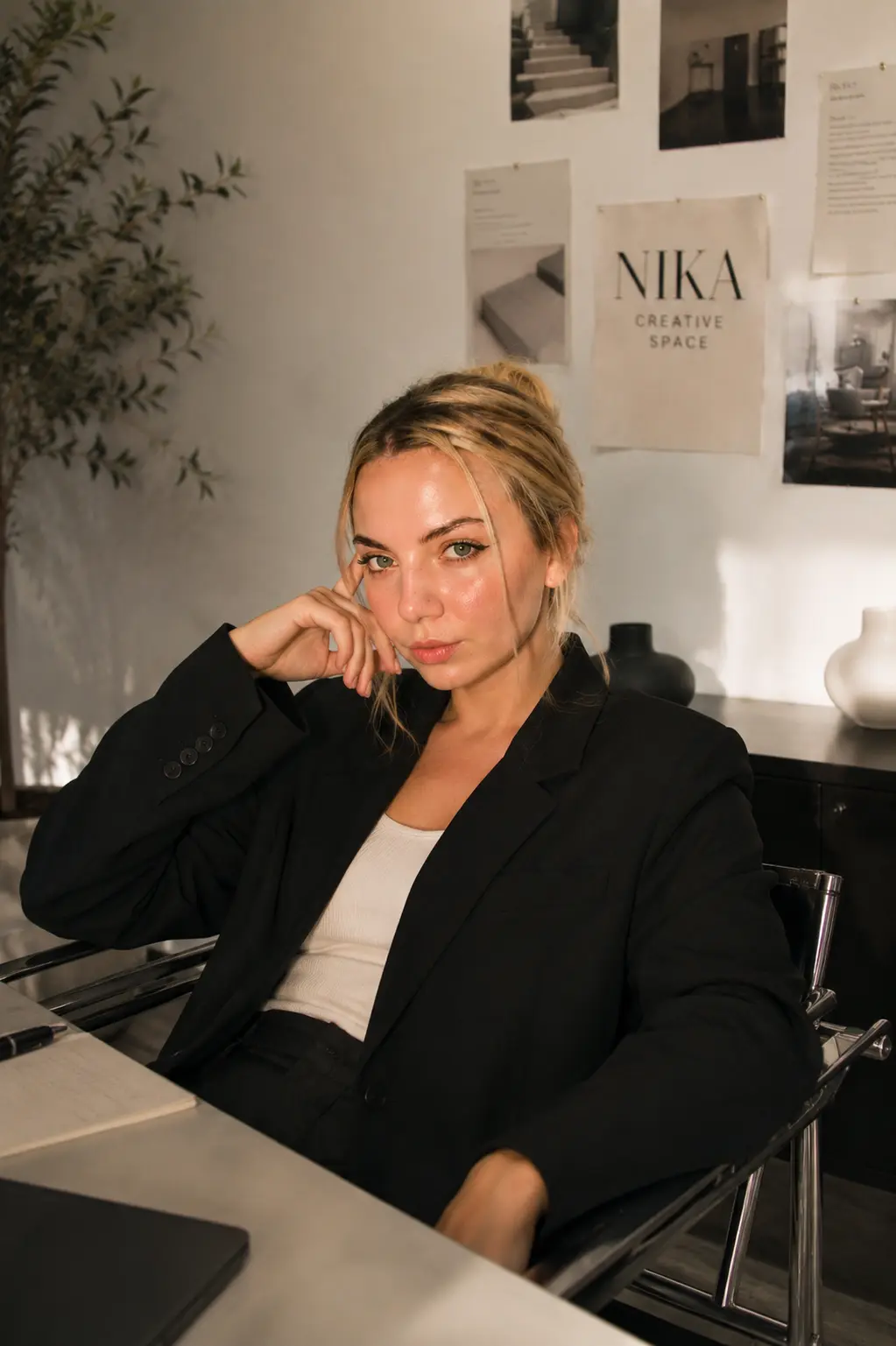 Veronika at her desk with the NIKA Creative Space moodboard behind her